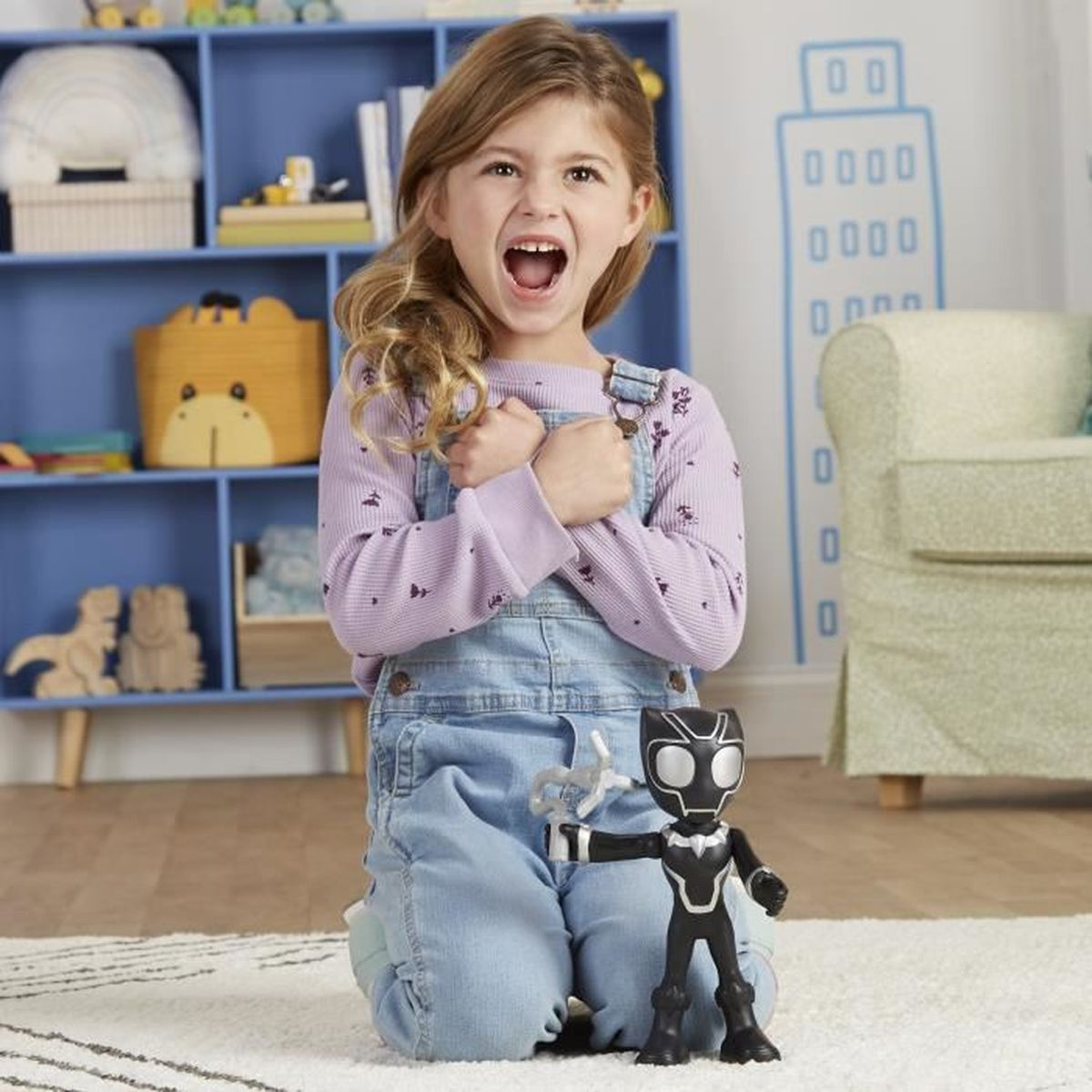 Dziewczynka klęczy, wygląda na zaskoczoną, trzymając figurkę Black Panther. Tło z zabawkami i meblami.