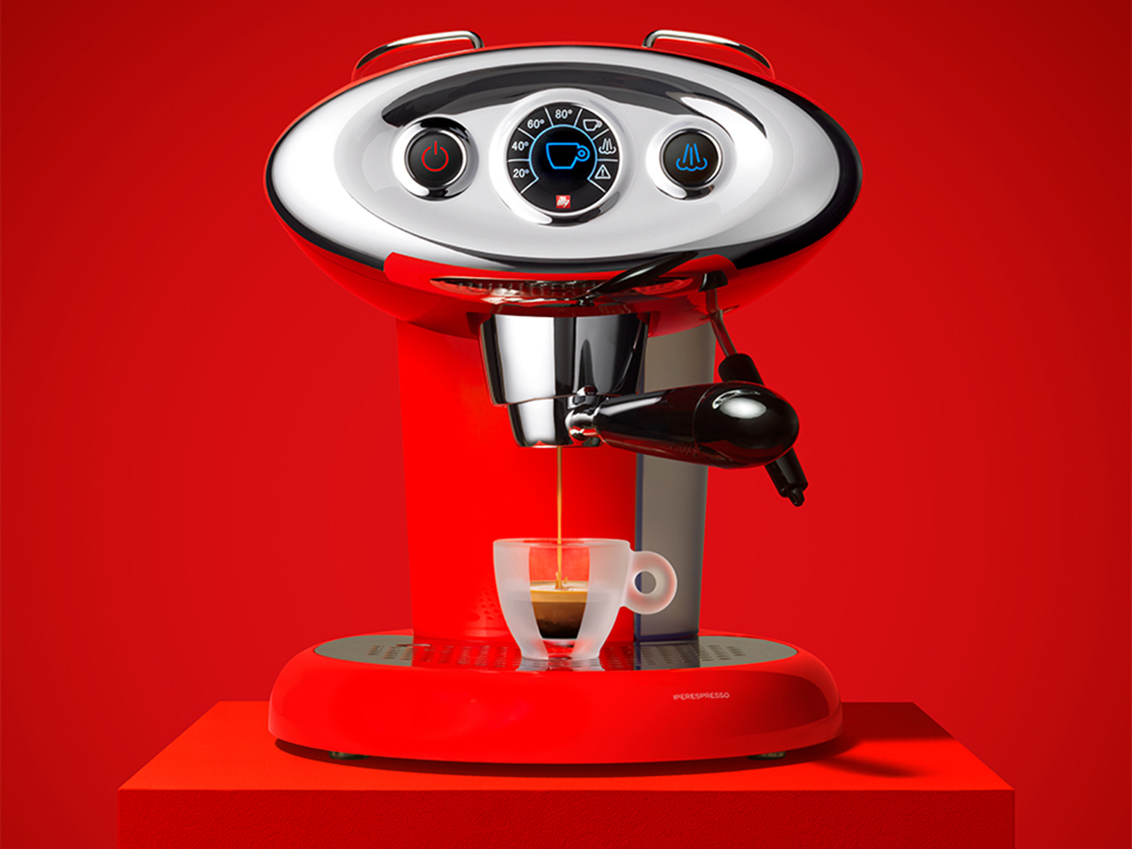 Czerwony ekspres do espresso, chromowane akcenty, wlewanie espresso do szklanki, czerwone tło.