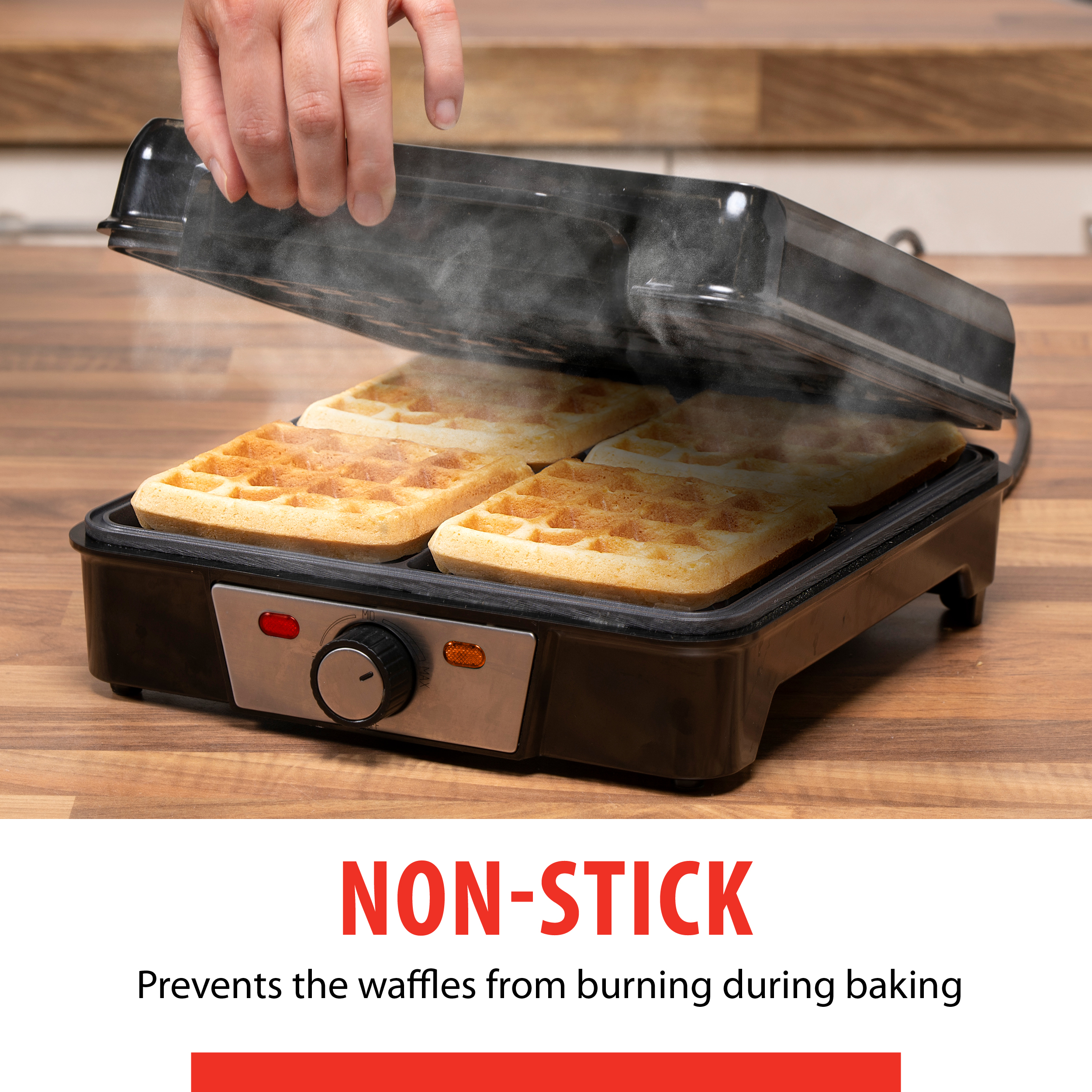 A person opening a black waffle maker with waffles inside, steam rising.