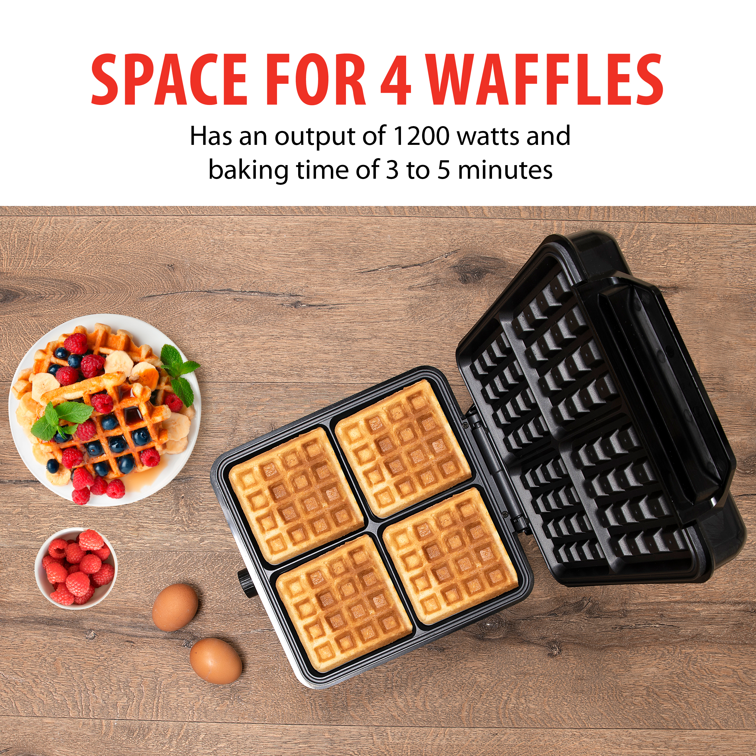 Waffle maker with four waffles inside. Waffles and berries are on a plate. Eggs are on the table.