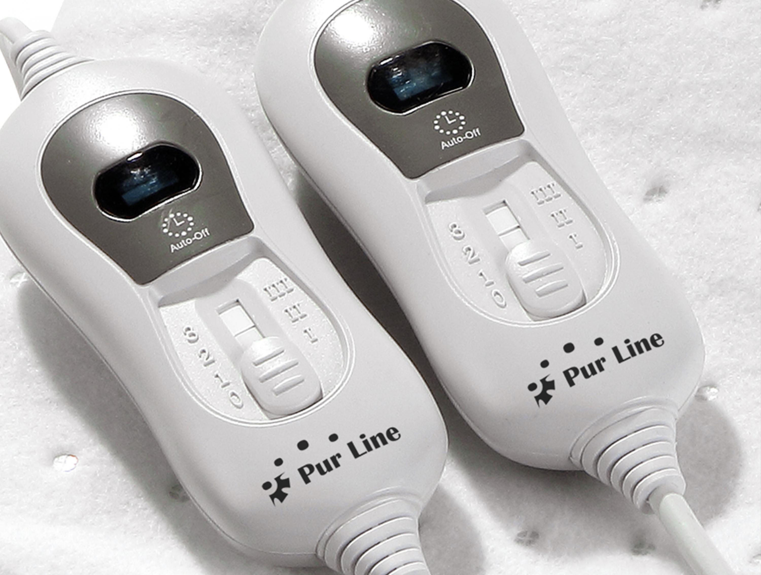 Dos controles de manta eléctrica blancos con ajustes, etiquetados Pur Line, sobre tela blanca.