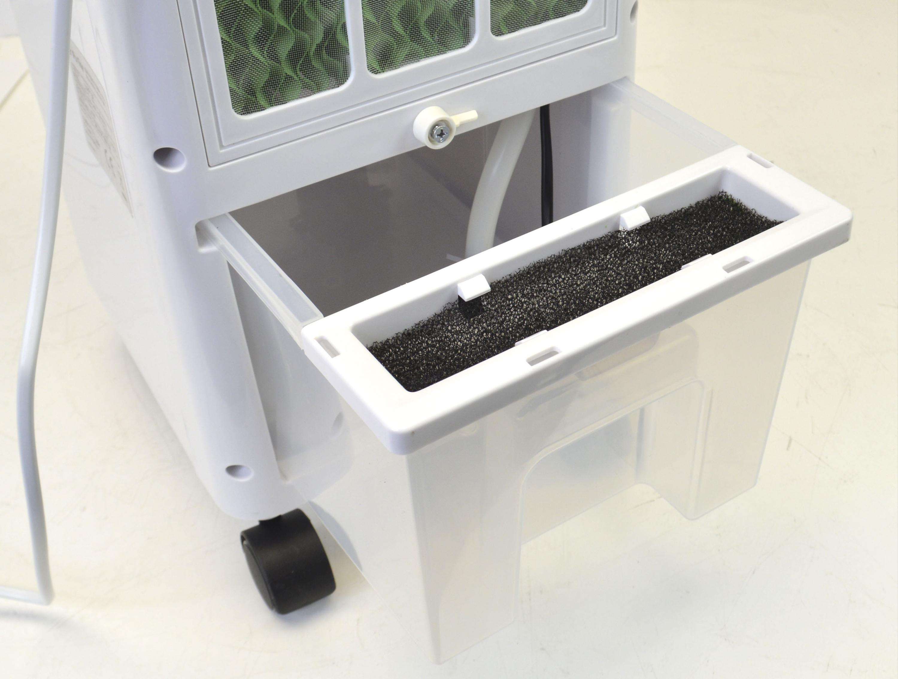 Weißer Luftkühler mit Wassertank und Filter. Der Filter ist schwarz, das Gerät hat ein Rad.