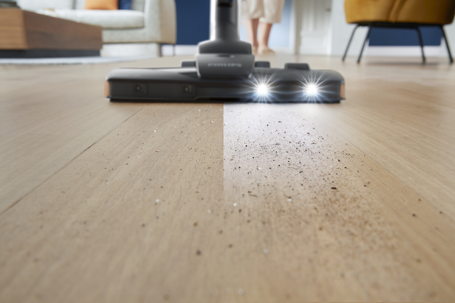 Głowica odkurzacza ze światłami jest pokazana na podłodze. Jedna strona jest czysta.