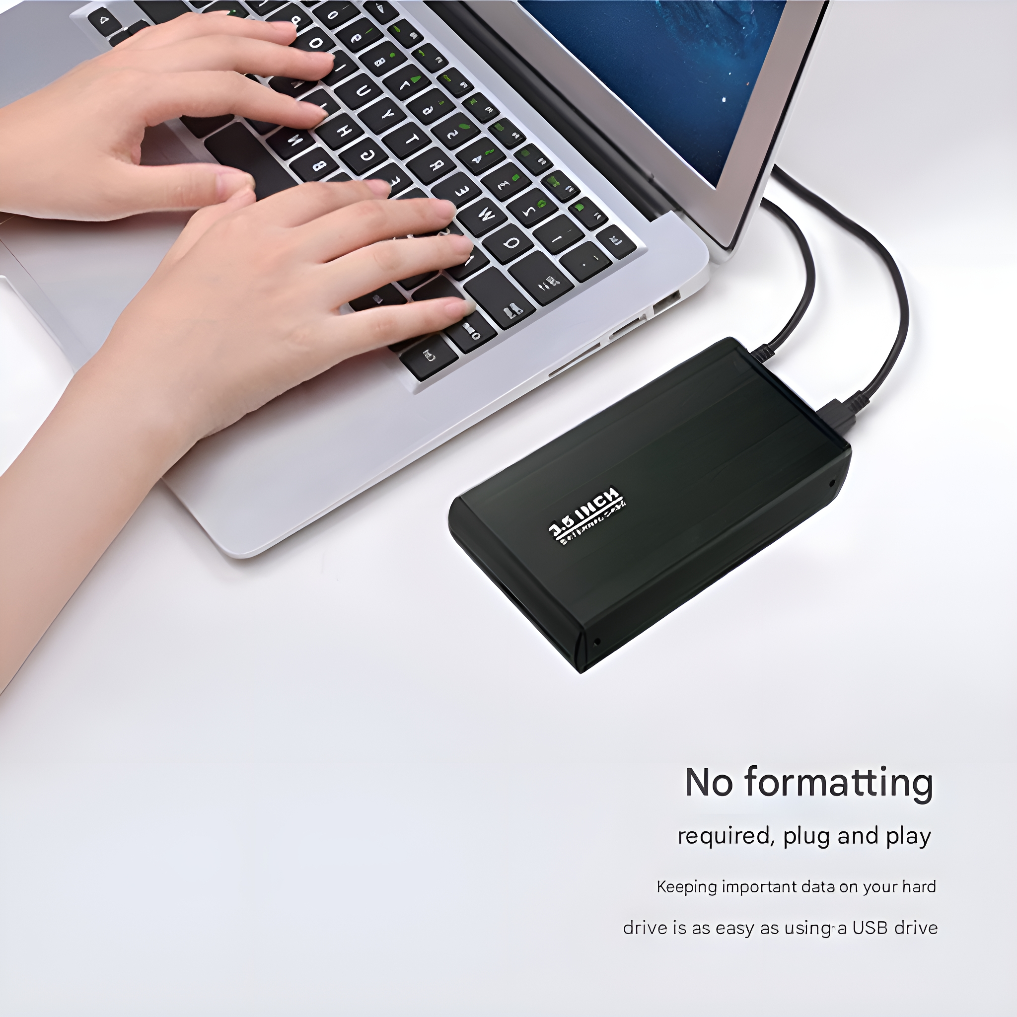 Eine schwarze externe Festplatte neben einem Laptop, auf dem Hände tippen.