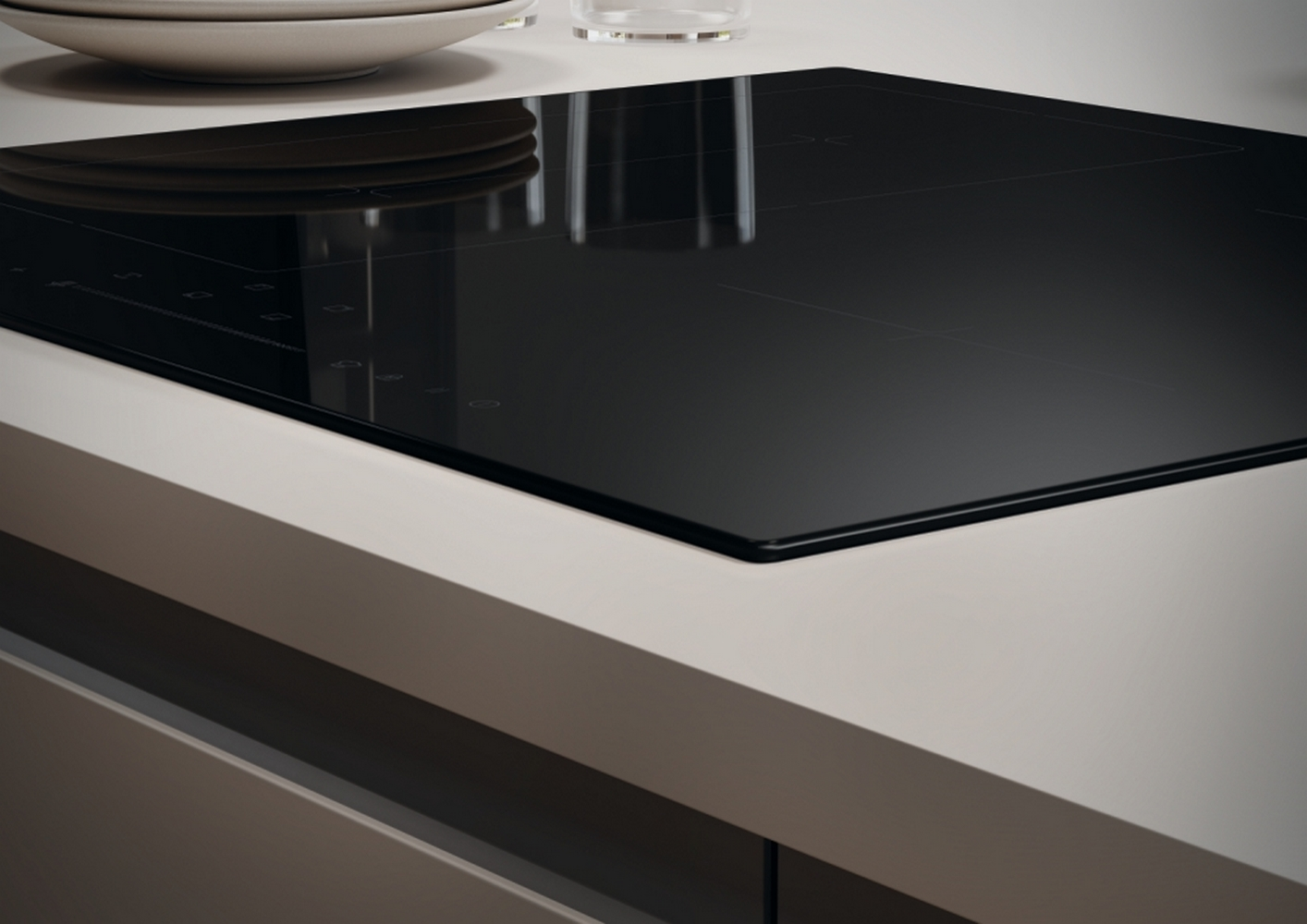 Nowoczesna czarna płyta indukcyjna na jasnym blacie. Płyta odbija światło.