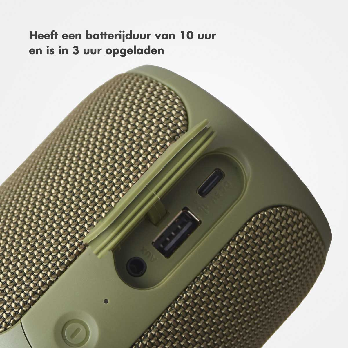 Close-up van een groene luidspreker met een mesh-hoes, met een USB-poort en AUX-ingang.