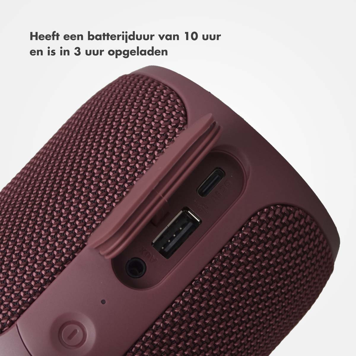 Een bordeauxrode draagbare luidspreker met ingangspoorten, close-up.