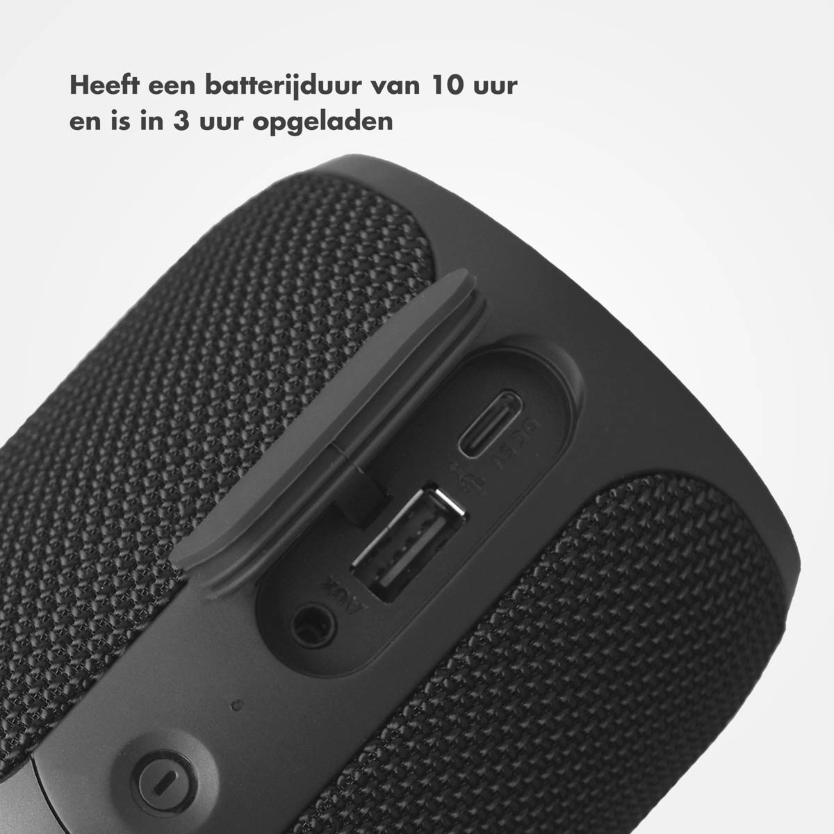 Zwarte, cilindrische luidspreker met oplaadpoorten en een zichtbare USB-poort.