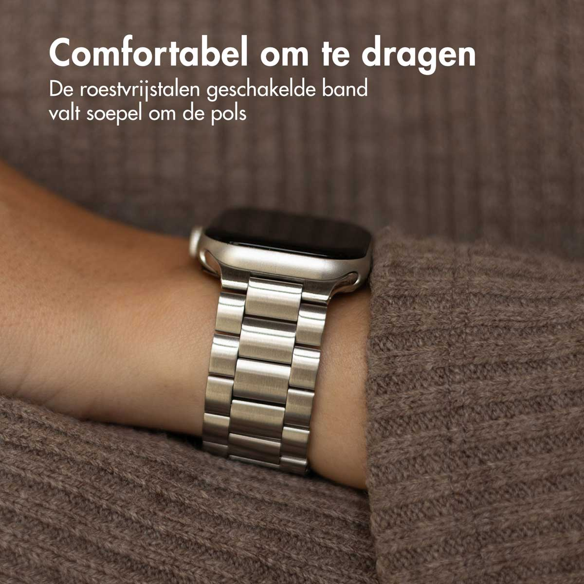 A silver watch with a metal band is on a person's wrist, close-up.