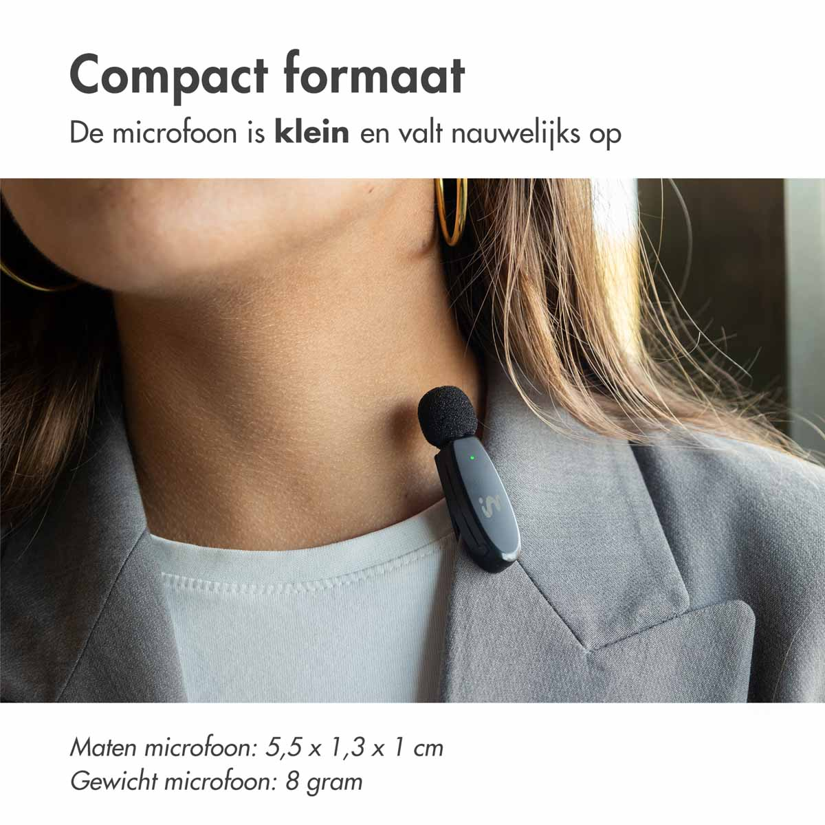 Kleine microfoon bevestigd aan de nek van een persoon. De persoon draagt een blazer.