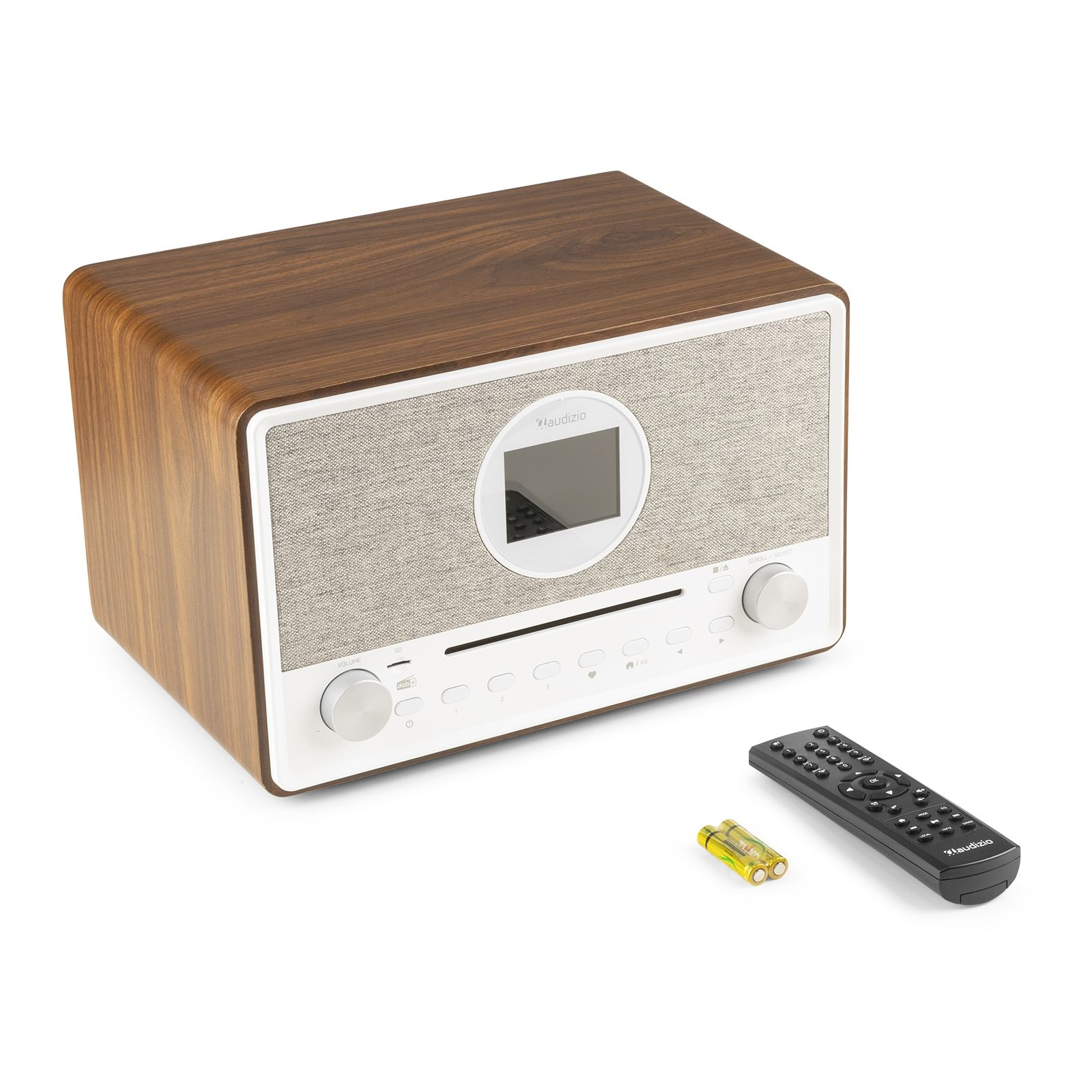 Una radio de madera con pantalla, botones y mando a distancia, con pilas al lado, sobre una superficie blanca.