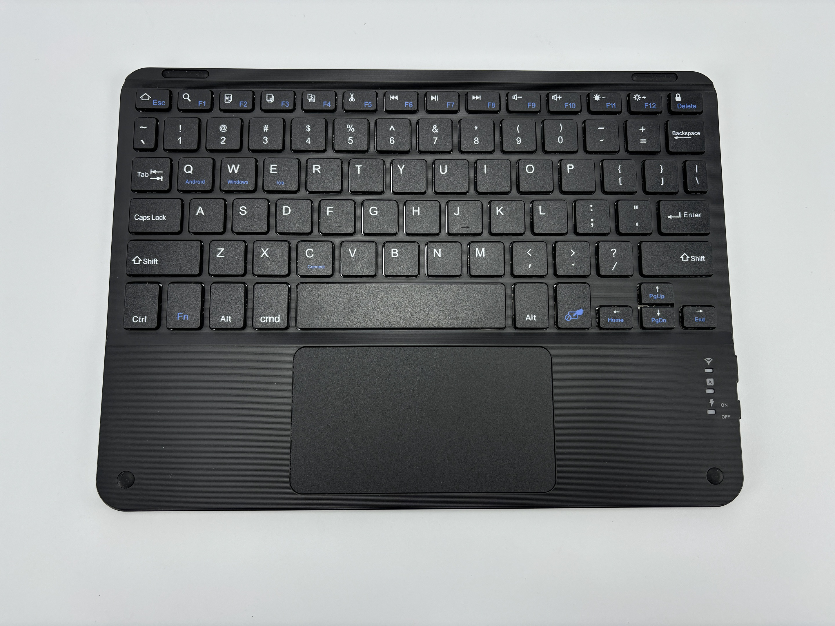 Zwart toetsenbord met een touchpad. Witte toetsen en blauwe functietoetsen. Bovenaanzicht.