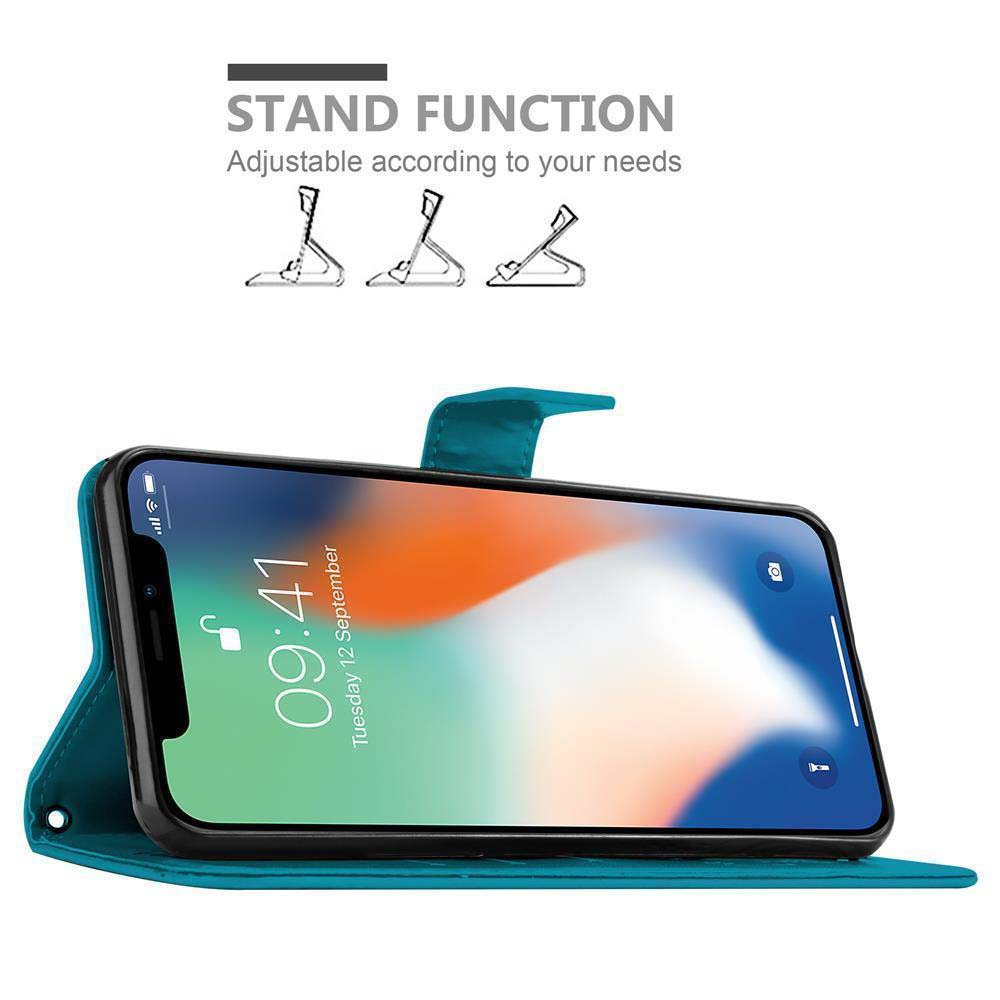 Una custodia per telefono verde acqua con uno smartphone che mostra una schermata iniziale con l'ora, su un tavolo.