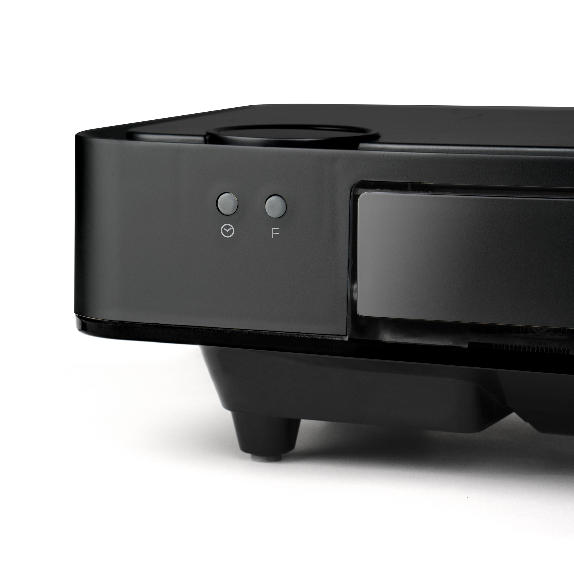 Zbliżenie czarnego urządzenia z dwoma przyciskami i szczeliną na dysk, na białej powierzchni.