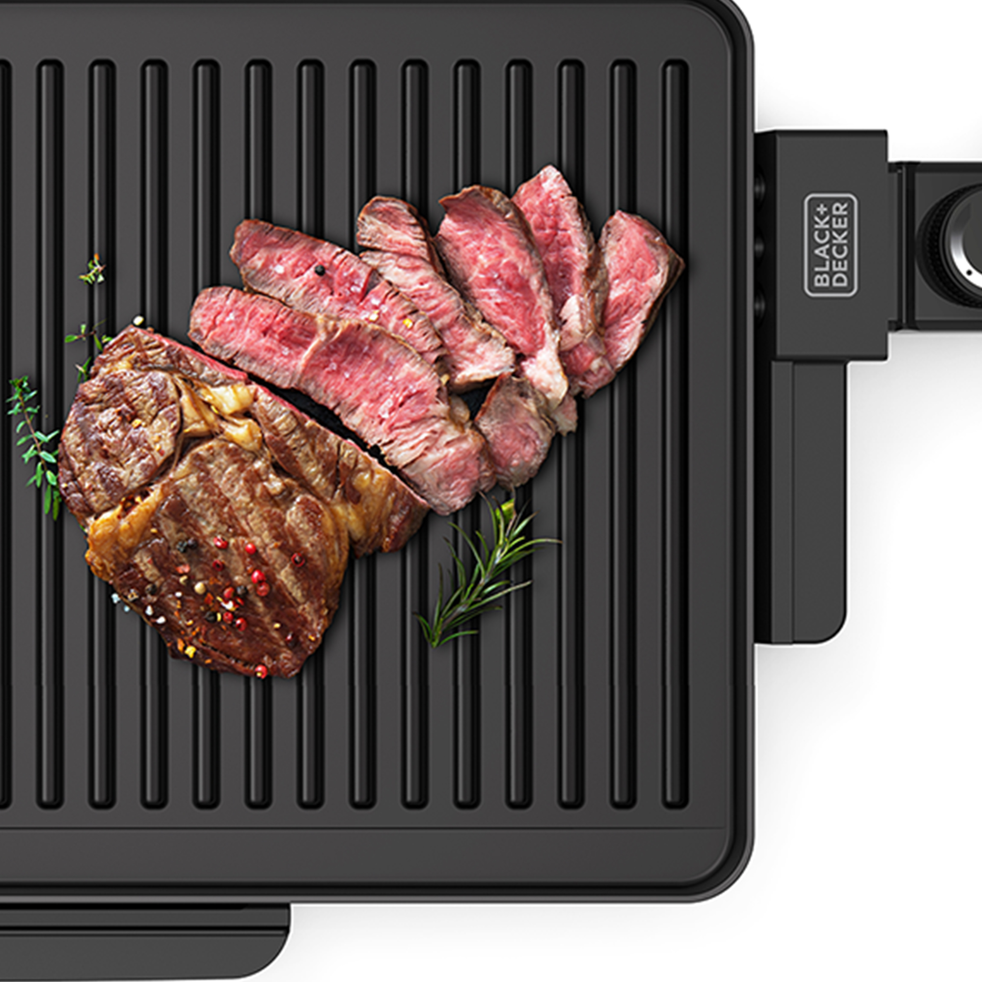 Widok z góry na czarny grill z ugotowanymi stekami i ziołami, z logo Black+Decker.