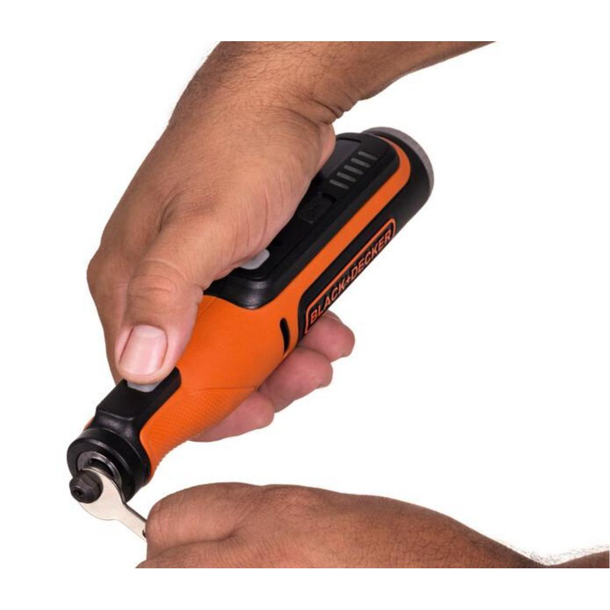 Hände einer Person, die ein schwarz-oranges Black+Decker-Rotationswerkzeug halten und einen Schraubenschlüssel verwenden.