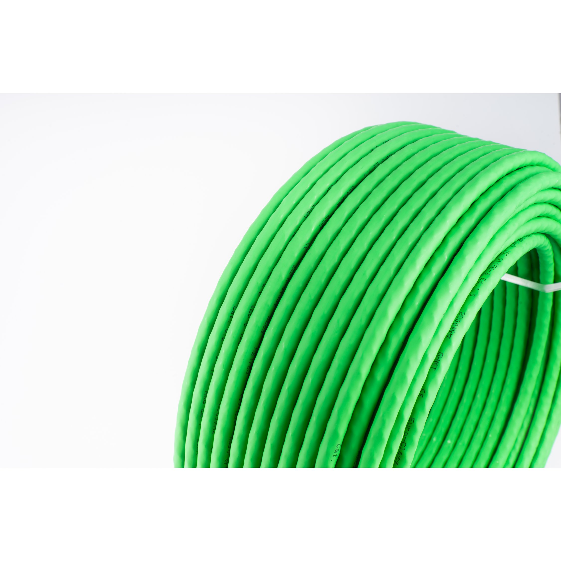 Cavo verde arrotolato su sfondo bianco. Il cavo è spesso.
