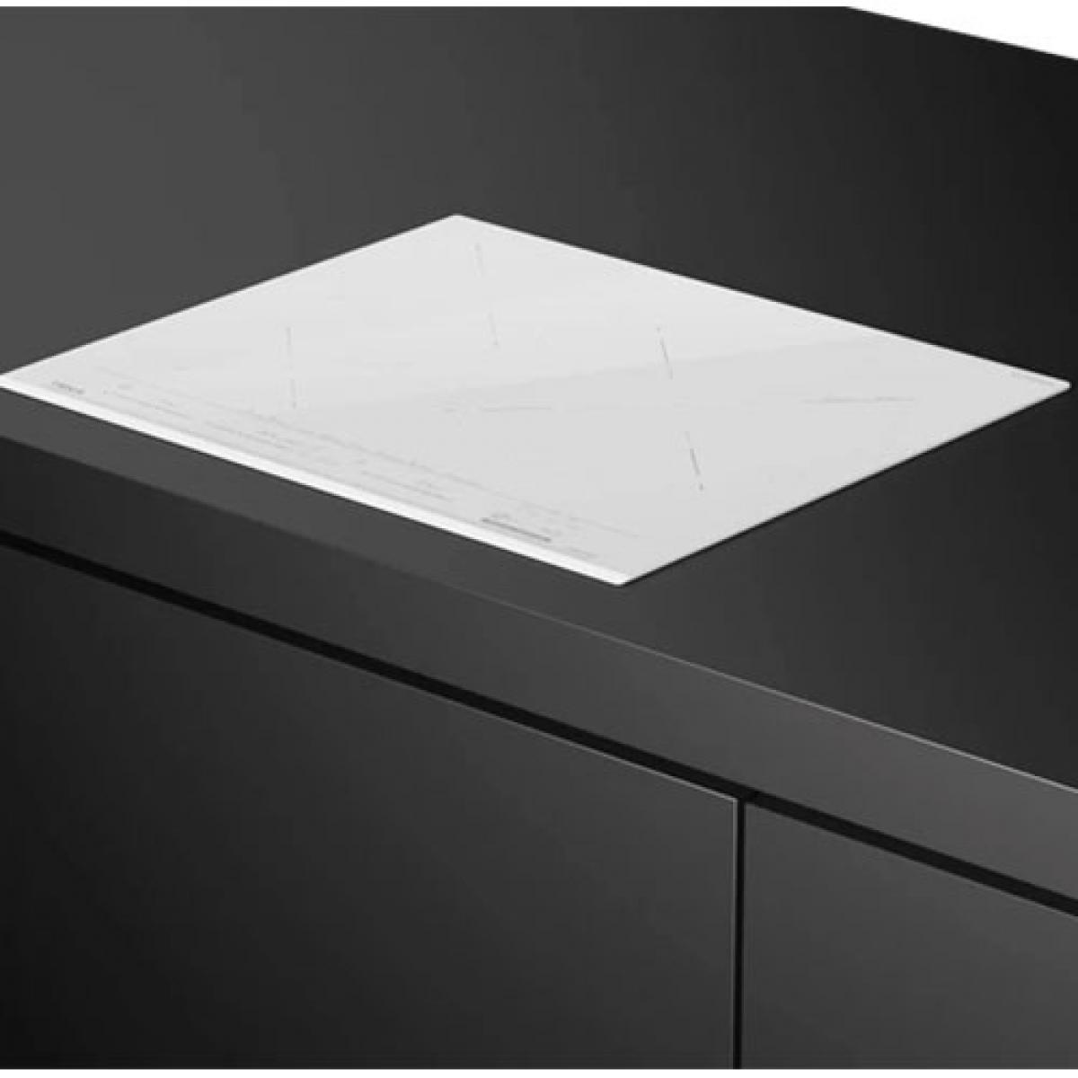 Biała płyta grzewcza na czarnym blacie o eleganckim designie.