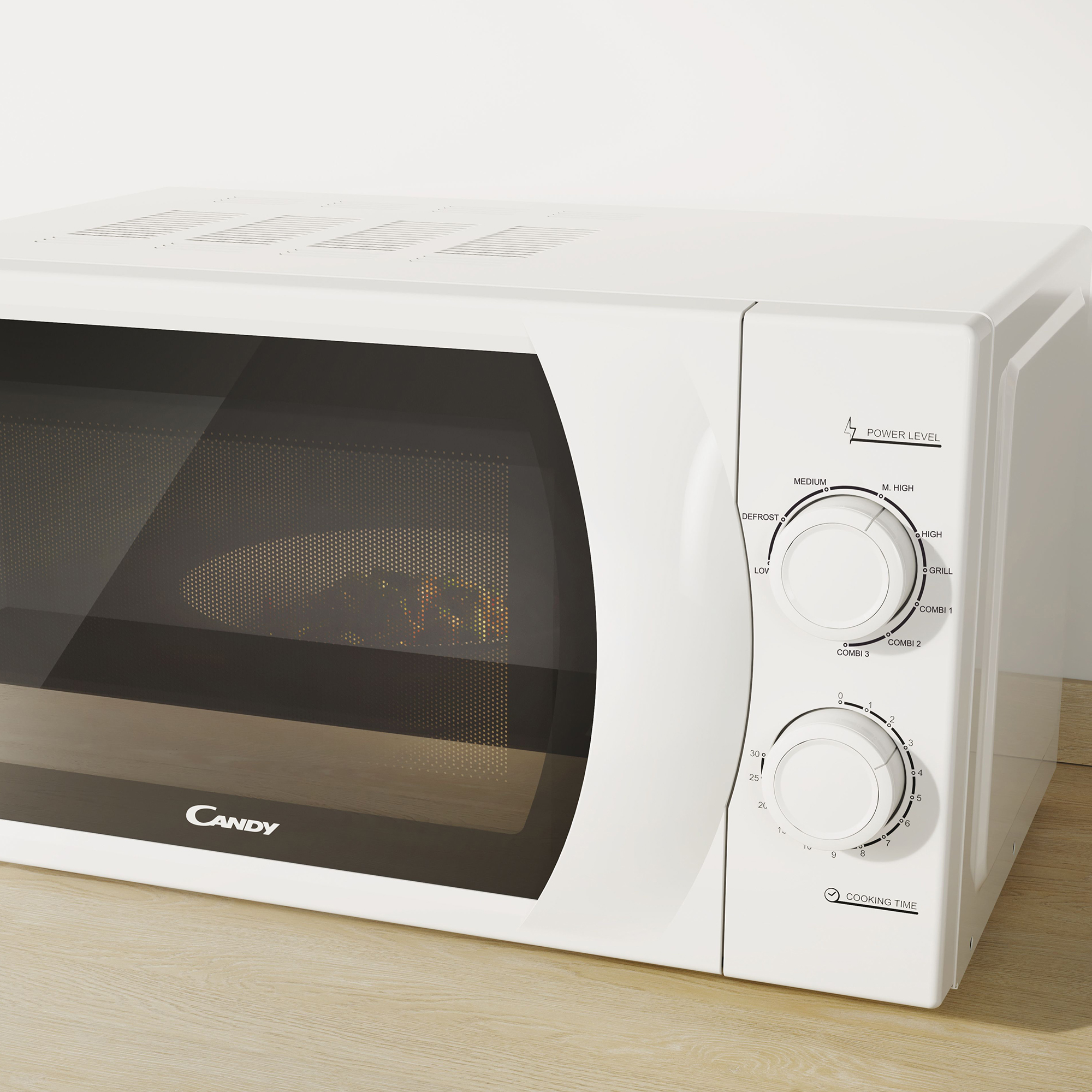 Biała kuchenka mikrofalowa Candy z elementami sterującymi po prawej, na drewnianej powierzchni.
