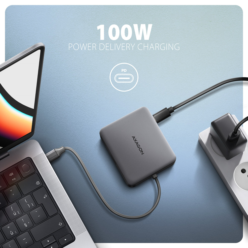 Laptop collegato a un hub grigio con testo 'AXAGON' e '100W', in carica.