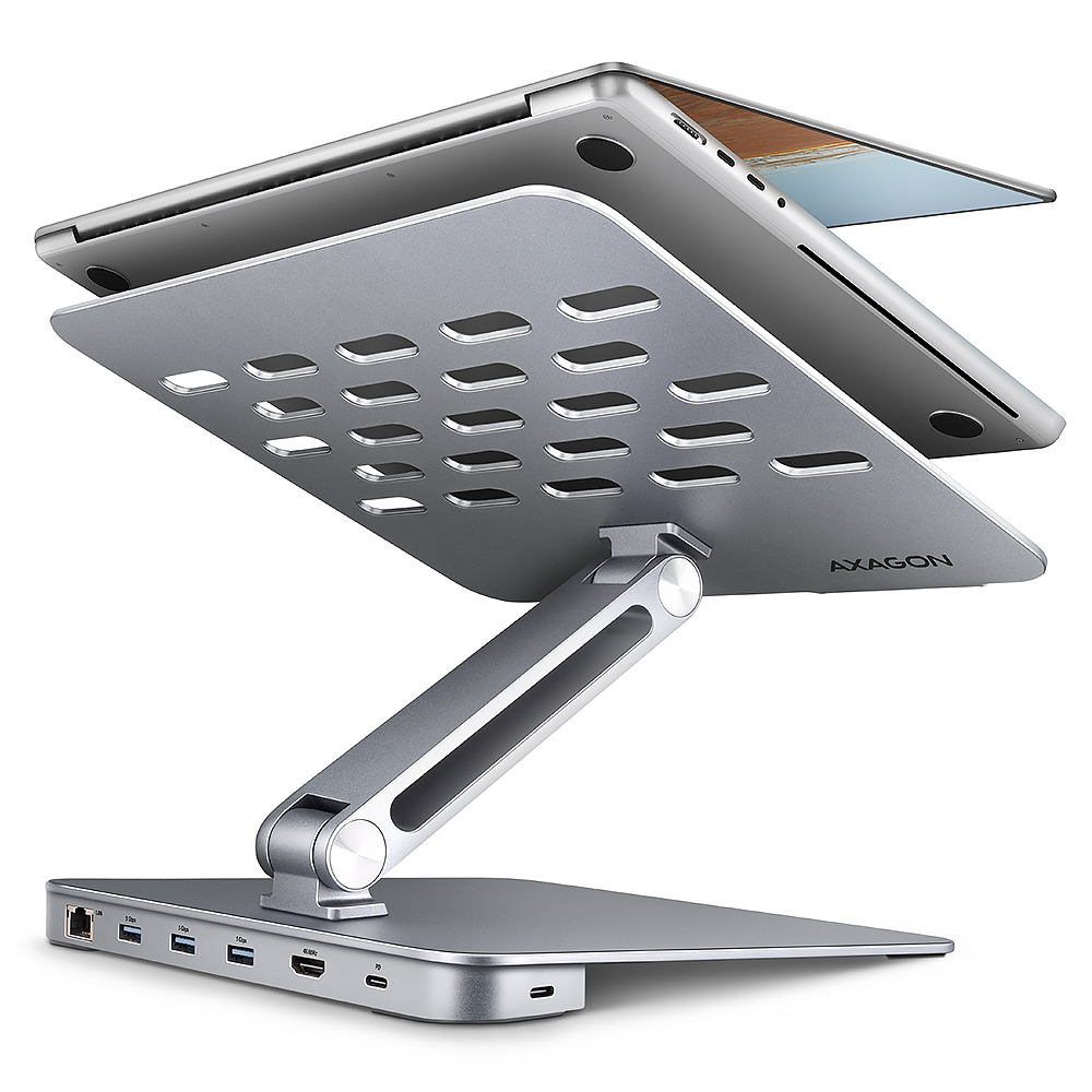 Supporto per laptop argentato con hub. Laptop sul supporto. Diverse porte visibili.