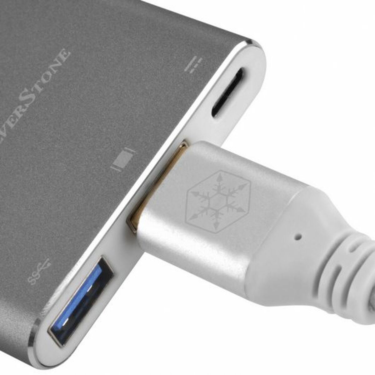 Un hub argentato con un cavo USB collegato, vista ravvicinata.