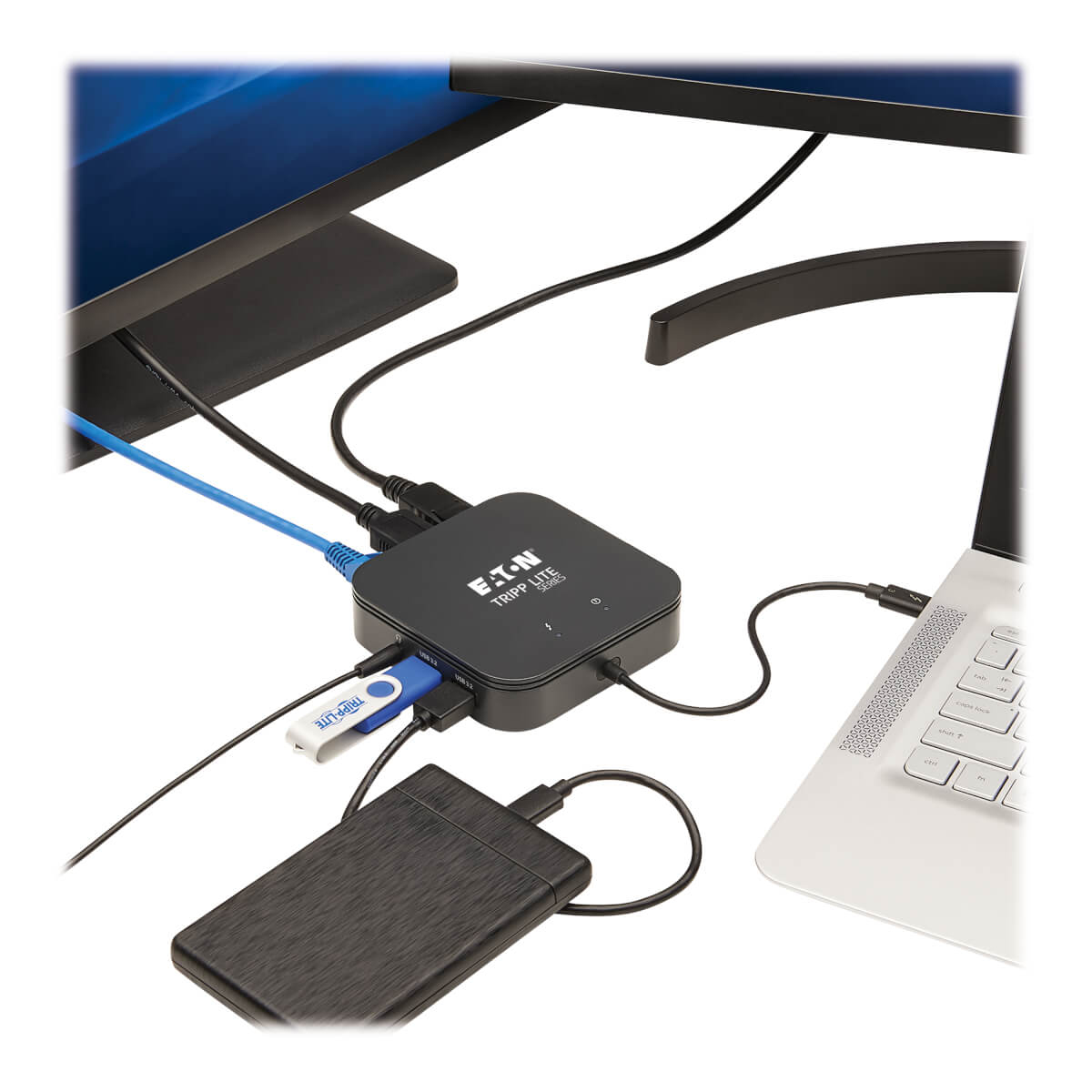 Hub nero collegato a un laptop, un disco rigido e un'unità USB. L'hub è su una scrivania.