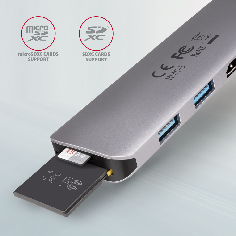 Un hub USB argentato con slot per schede e una scheda micro SD inserita. Logo CE FC.