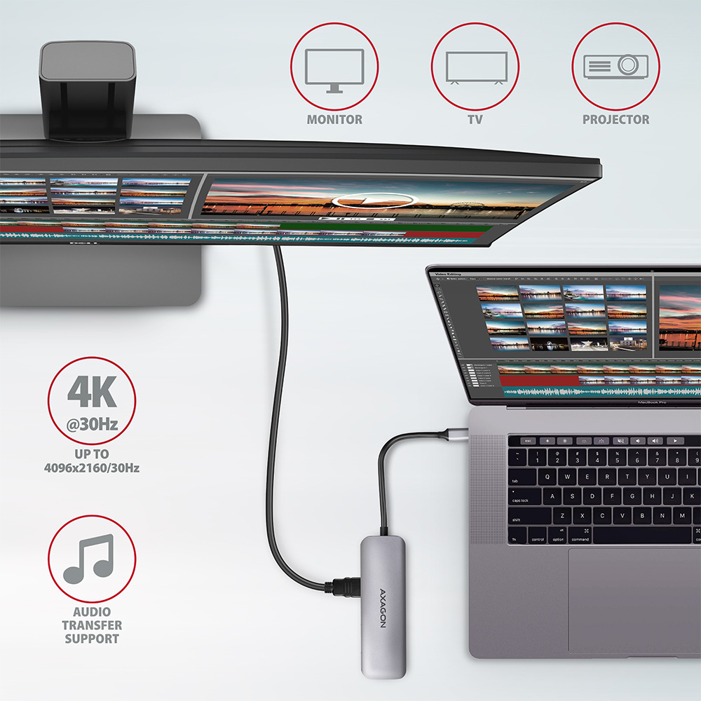 Un hub USB argento collegato a un laptop e a un monitor, che mostra contenuti, con dettagli sul supporto audio.