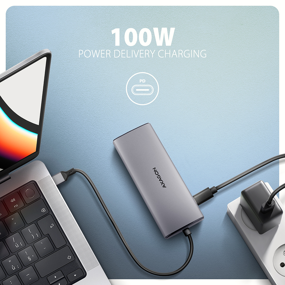 Laptop in carica con un adattatore USB-C grigio collegato a una presa a muro.