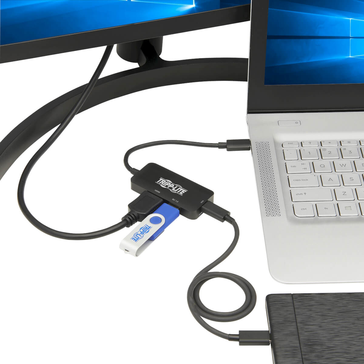 Un laptop collegato a un monitor e a un hub Tripp-Lite, a cui è collegata una chiavetta USB.