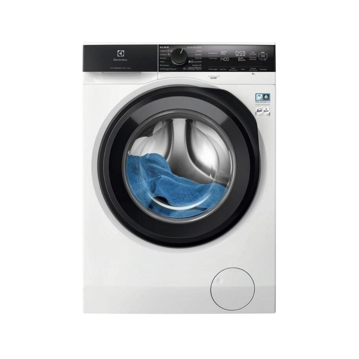 Una lavatrice bianca con un asciugamano blu all'interno, bordo nero e pannello comandi.
