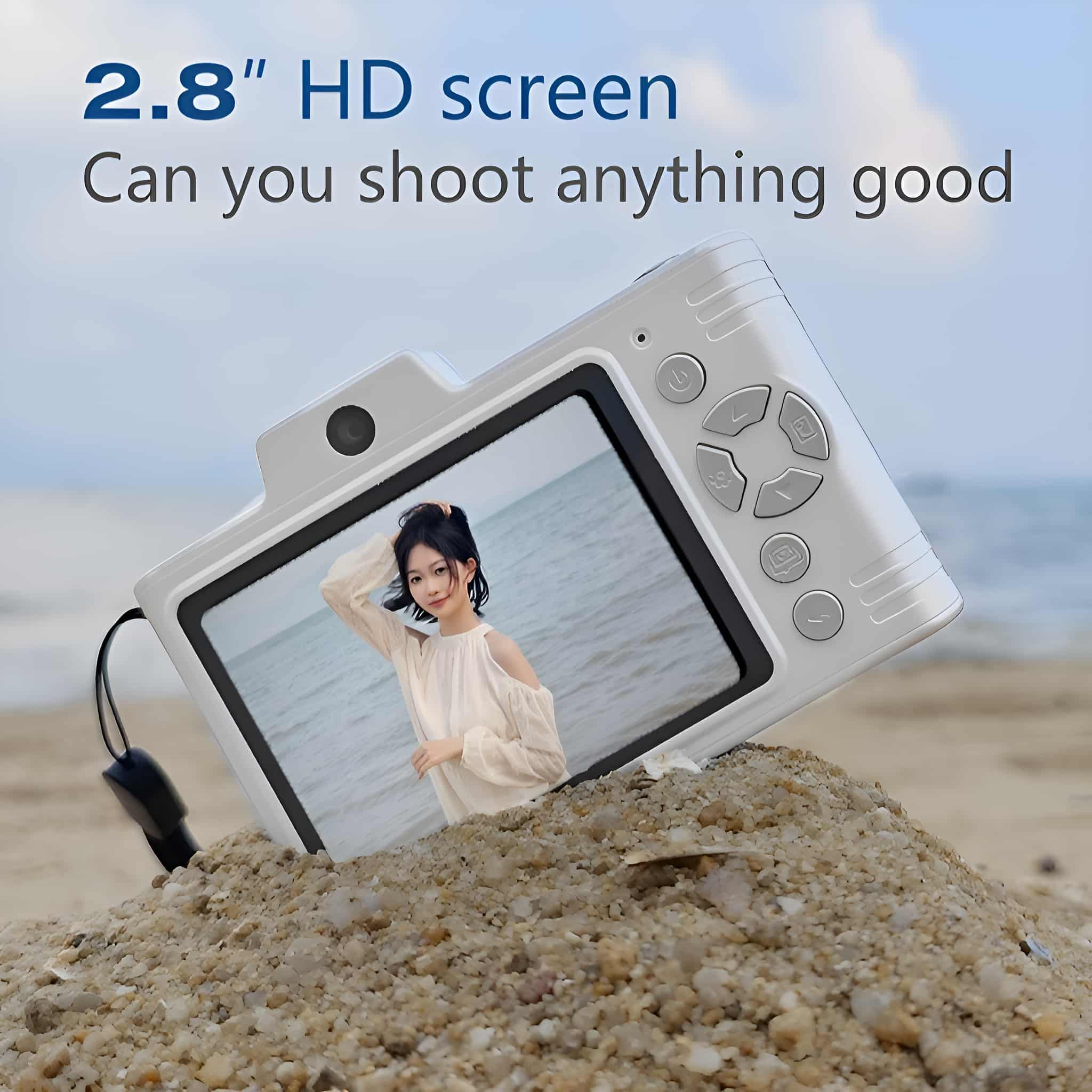 Weiße Digitalkamera auf Sand, zeigt ein Bild einer Frau auf dem Bildschirm, mit Textüberlagerung.