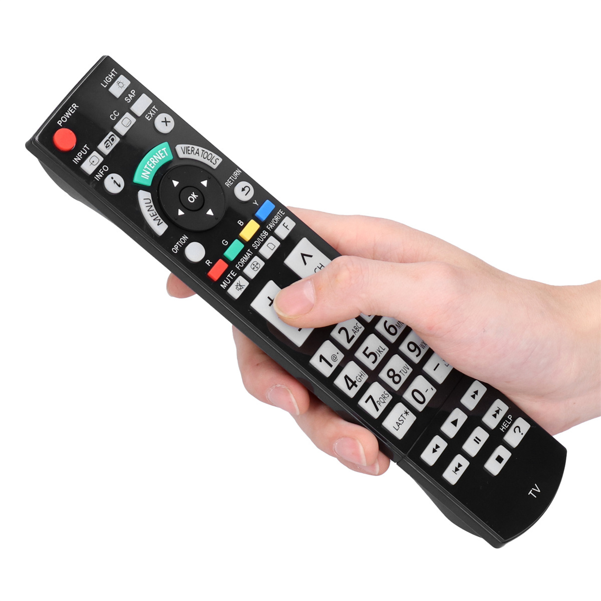 Eine Hand, die eine schwarze TV-Fernbedienung hält. Die Fernbedienung hat viele Tasten für verschiedene Funktionen.