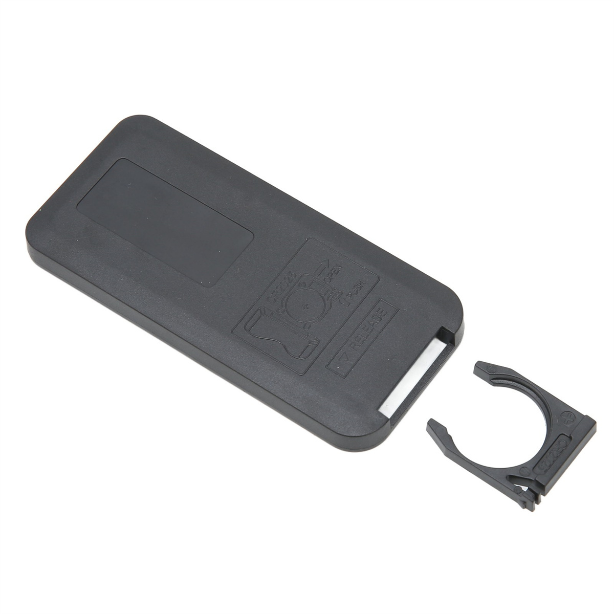 Eine schwarze Rückseite der Fernbedienung mit geöffnetem Batteriefach und abgenommenem Batteriebefestigungsclip.
