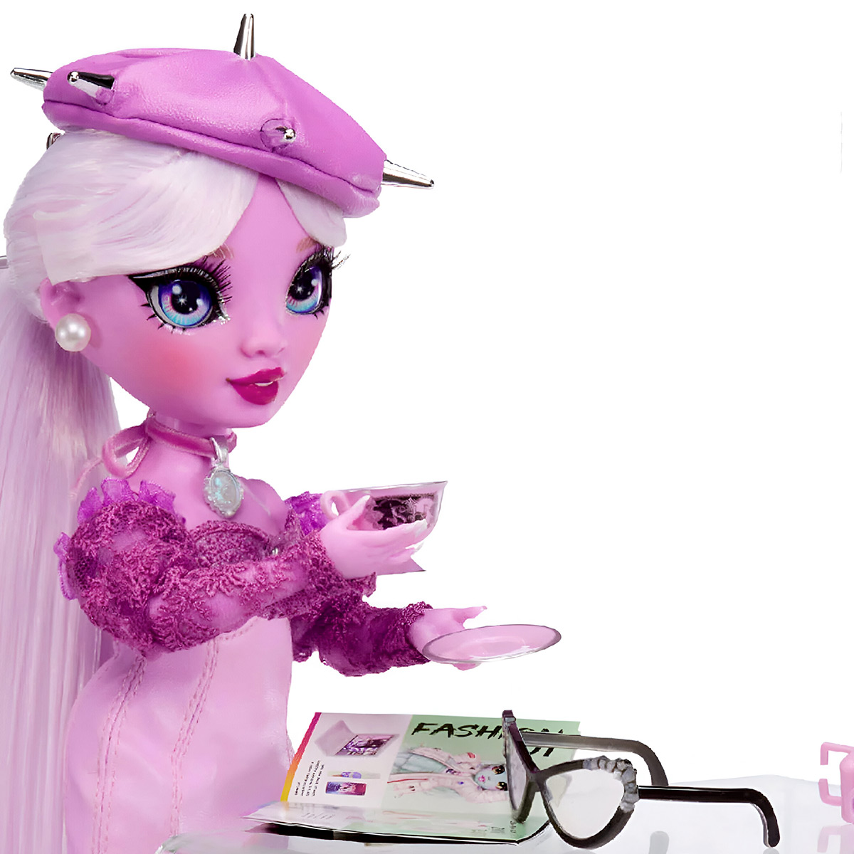 Eine Modepuppe in rosa Kleidung, die eine Teetasse hält. Brille und Zeitschrift im Vordergrund.