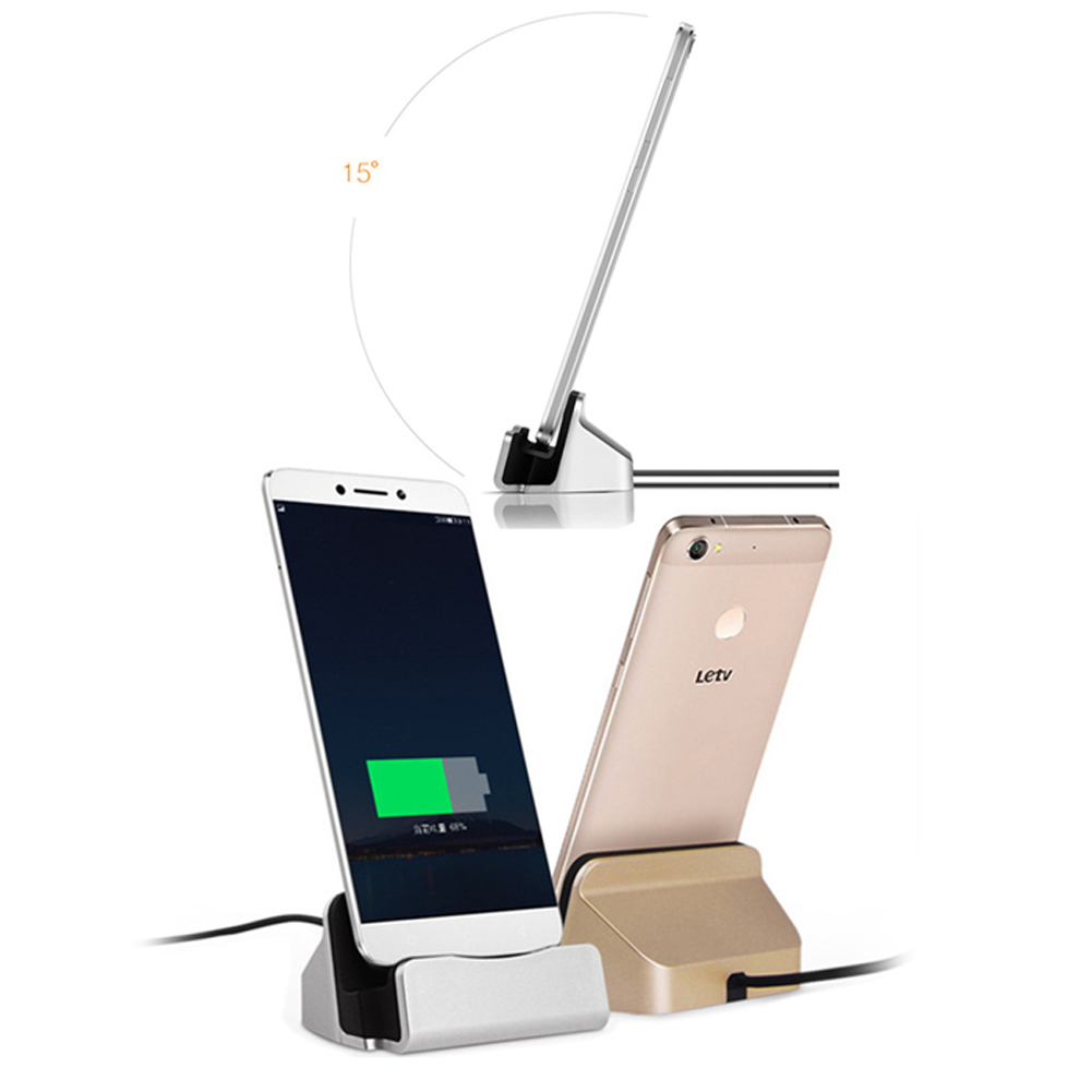 Zwei Telefone auf Ladegeräten. Eines zeigt einen Ladebildschirm, das andere ist goldfarben. Ein drittes Ladegerät ist aufrecht.