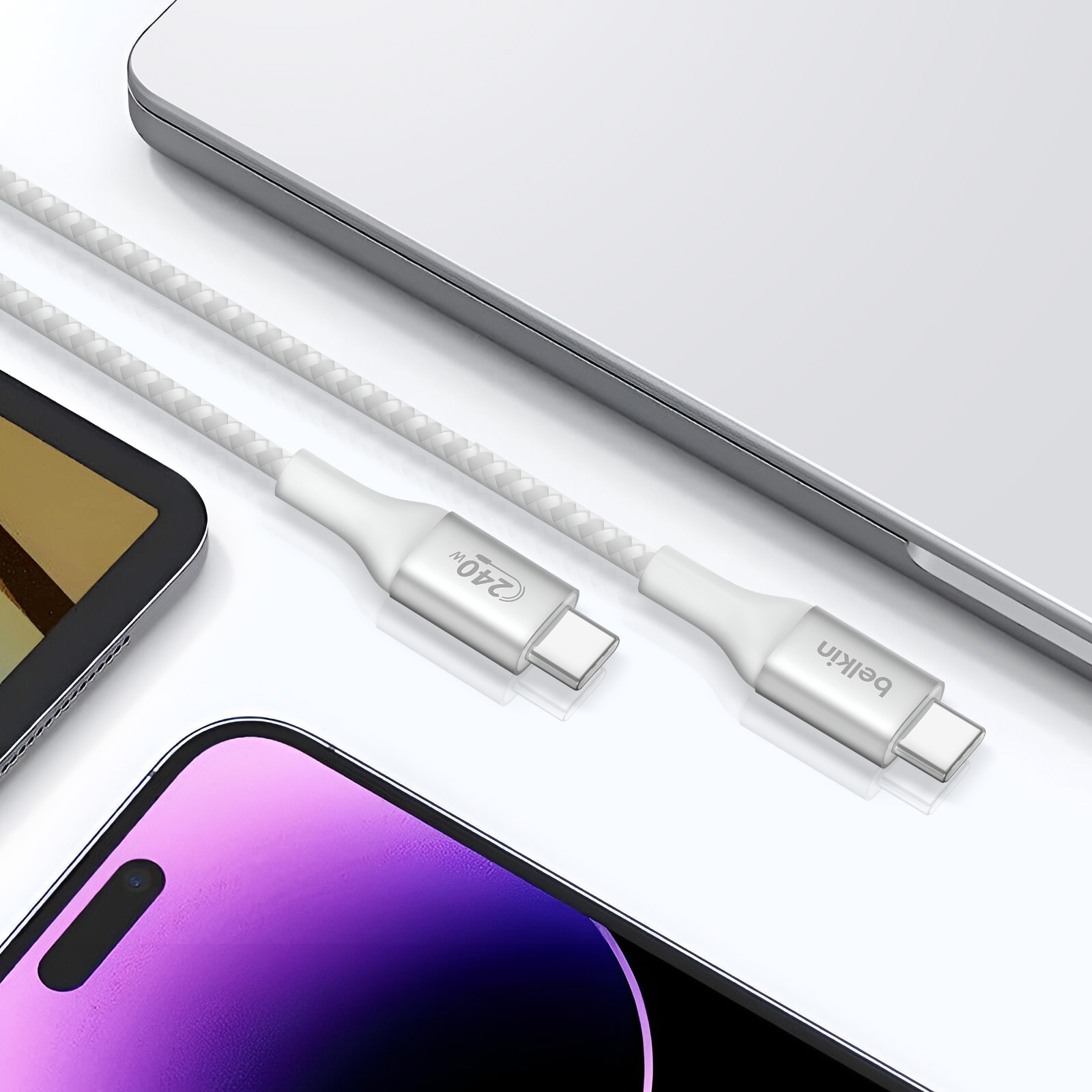 Twee witte USB-C-kabels naast een laptop, tablet en telefoon. Belkin logo.