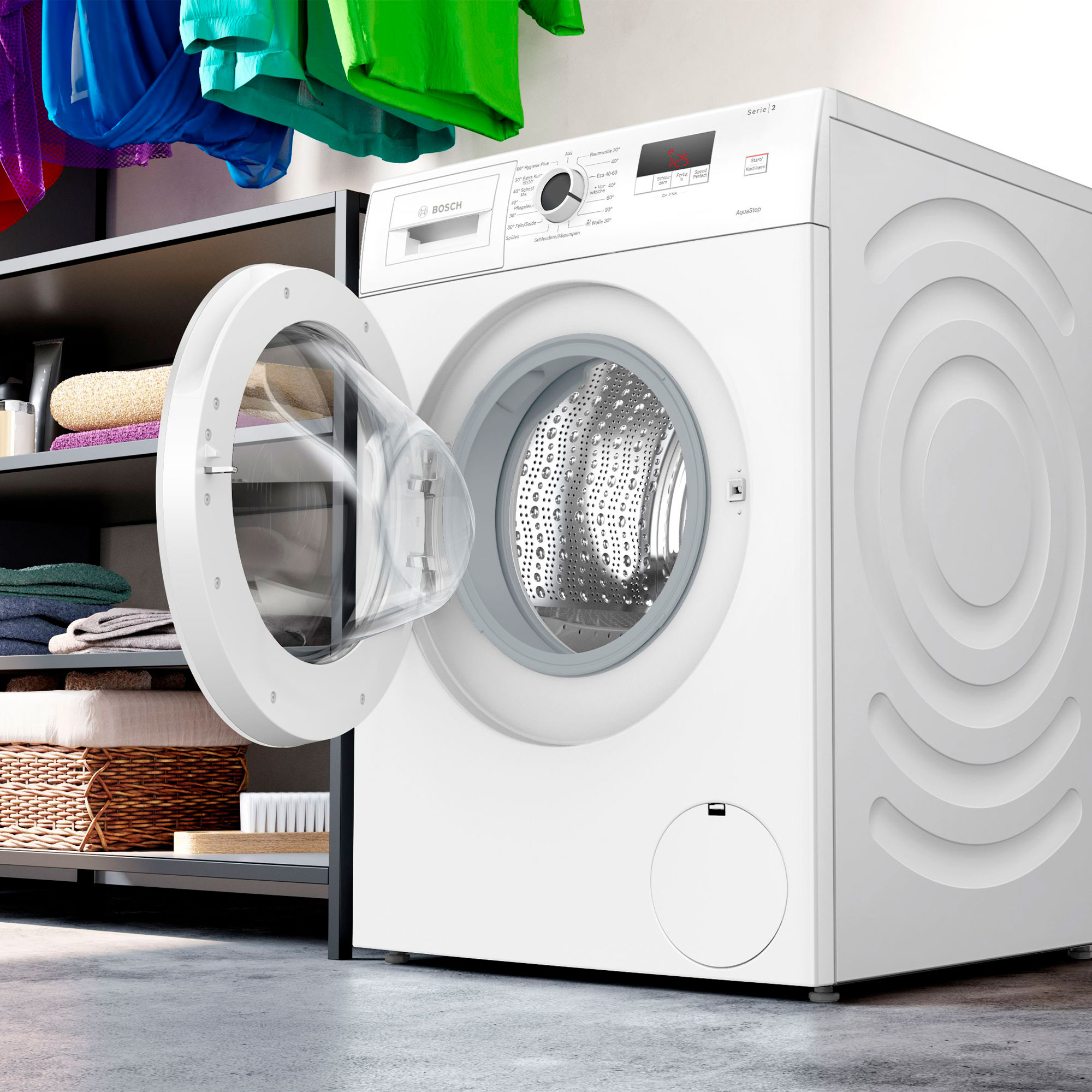 Weiße Bosch Waschmaschine mit offener Tür, Wäsche in der Nähe.