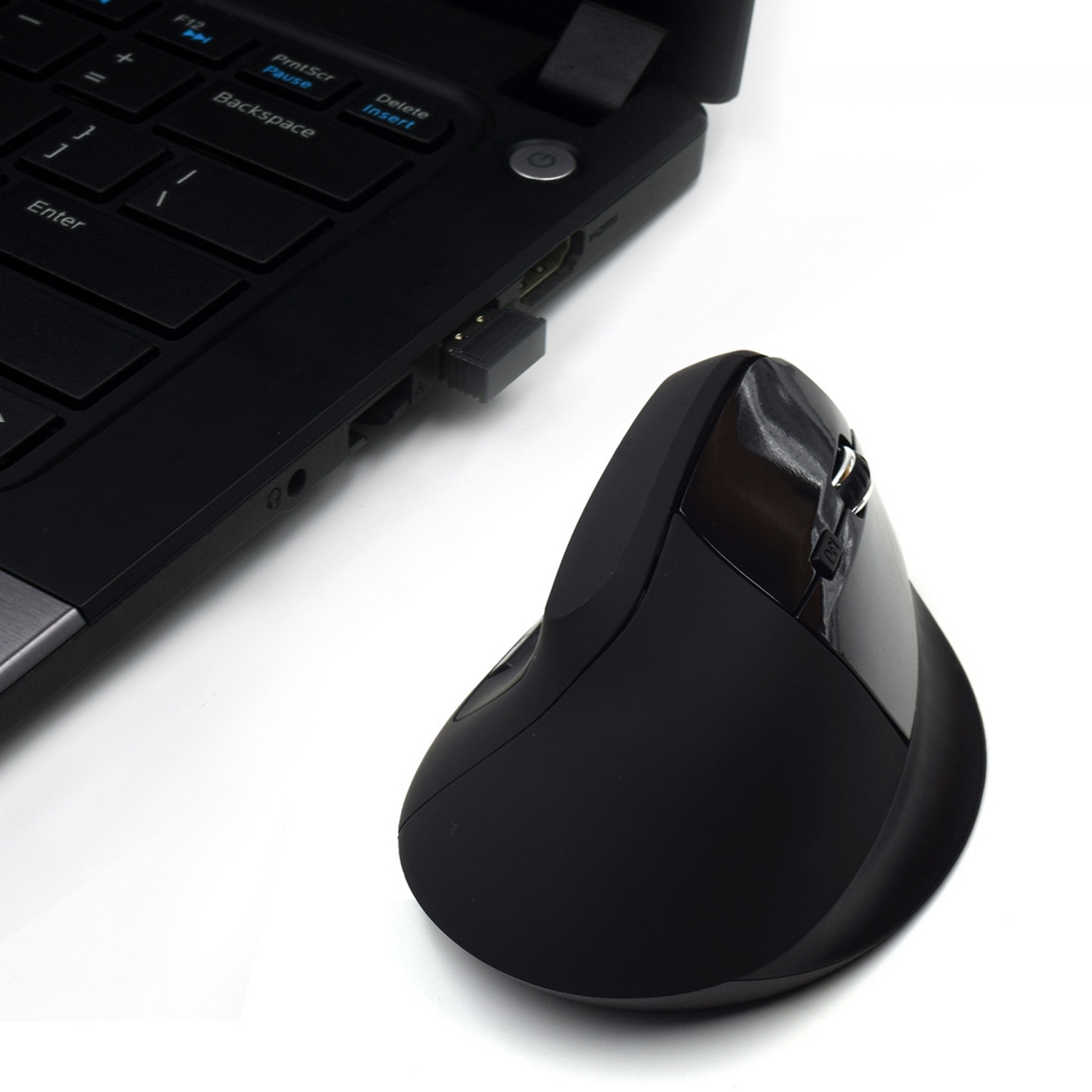 Schwarze ergonomische Maus, die an einen Laptop angeschlossen ist. Die Maus ist rechts.