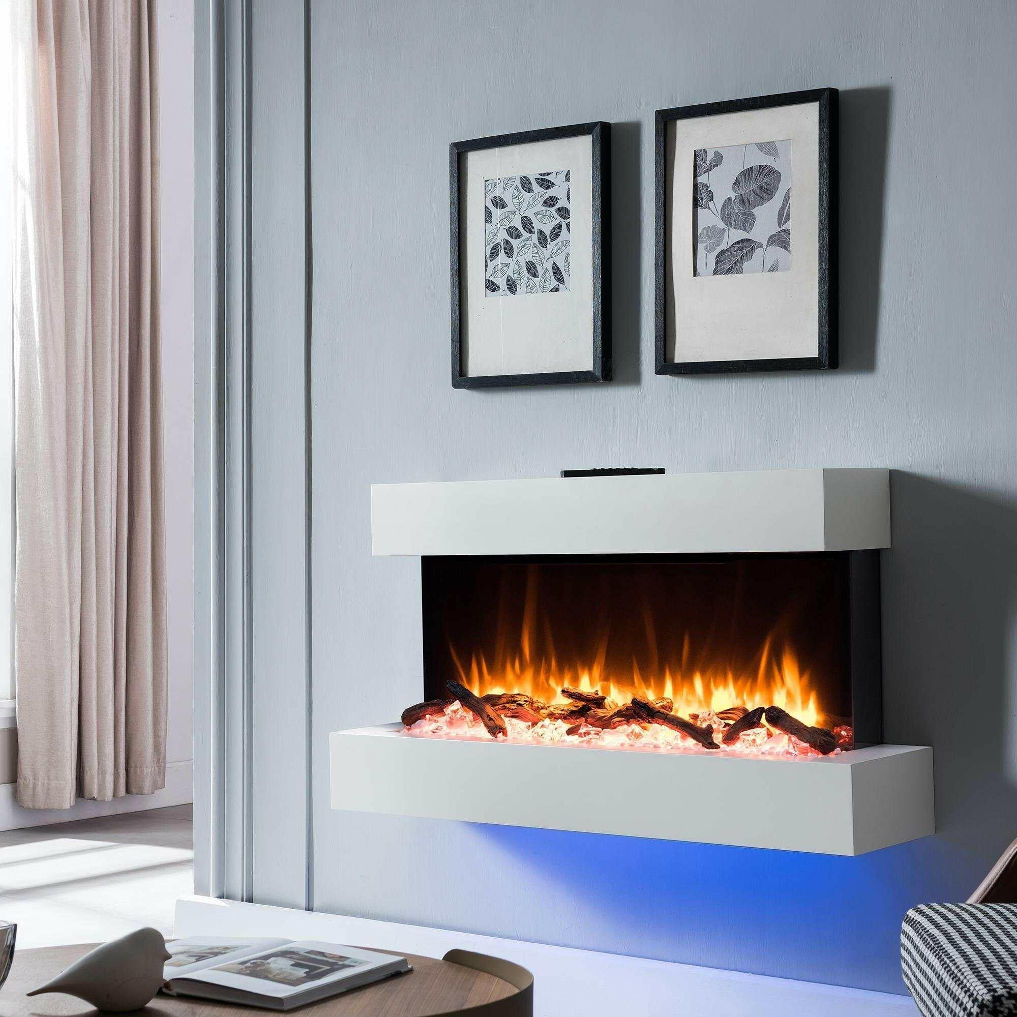 Elektrischer Kamin mit Flammen, Holzscheiten und blauem Licht, zwei gerahmte Bilder oben.