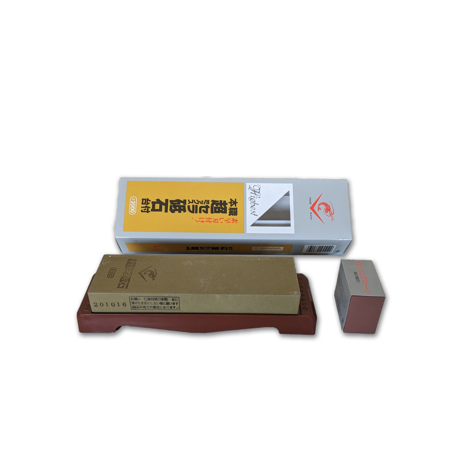 Un set di pietre per affilare, con una scatola e una piccola pietra, disposte su una base marrone, sfondo bianco.