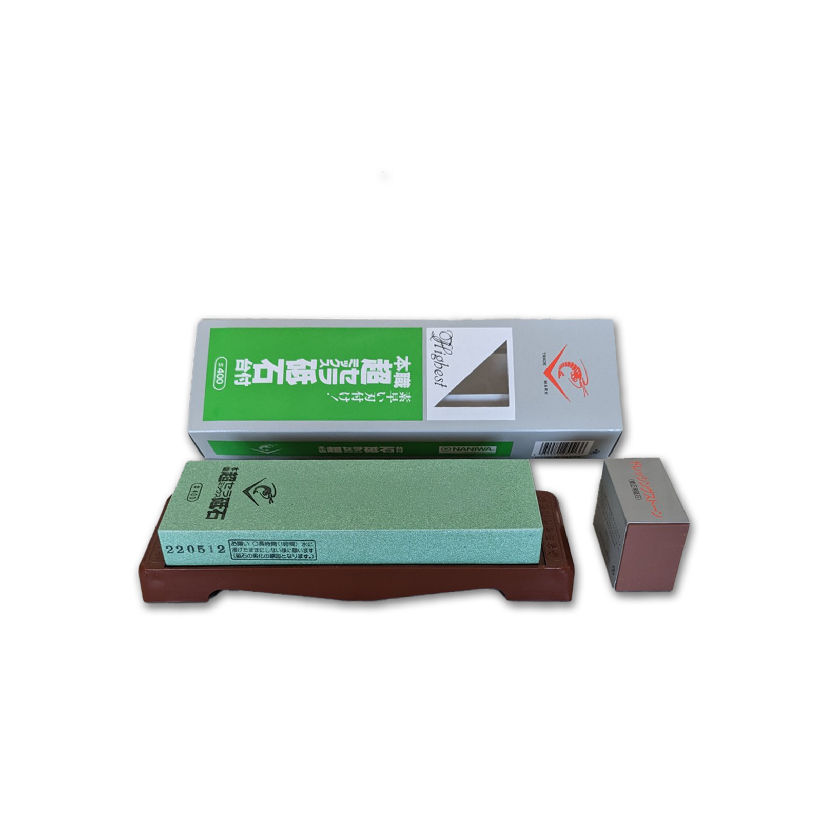 Una pietra per affilare verde, scatola e una pietra più piccola, su base in legno.