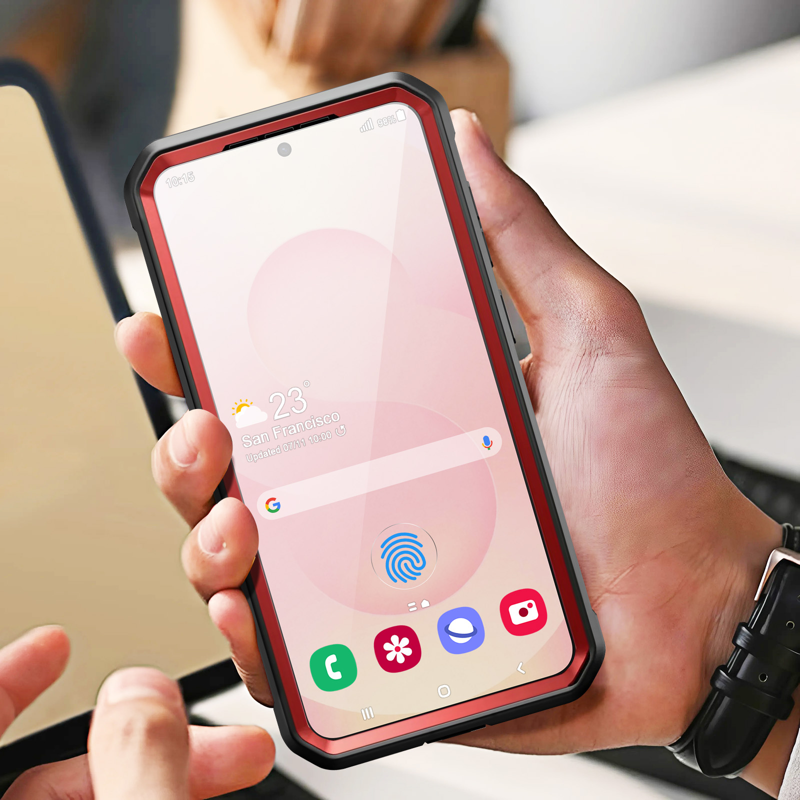 Una mano che tiene un telefono in una custodia protettiva. Lo schermo del telefono mostra un'app.
