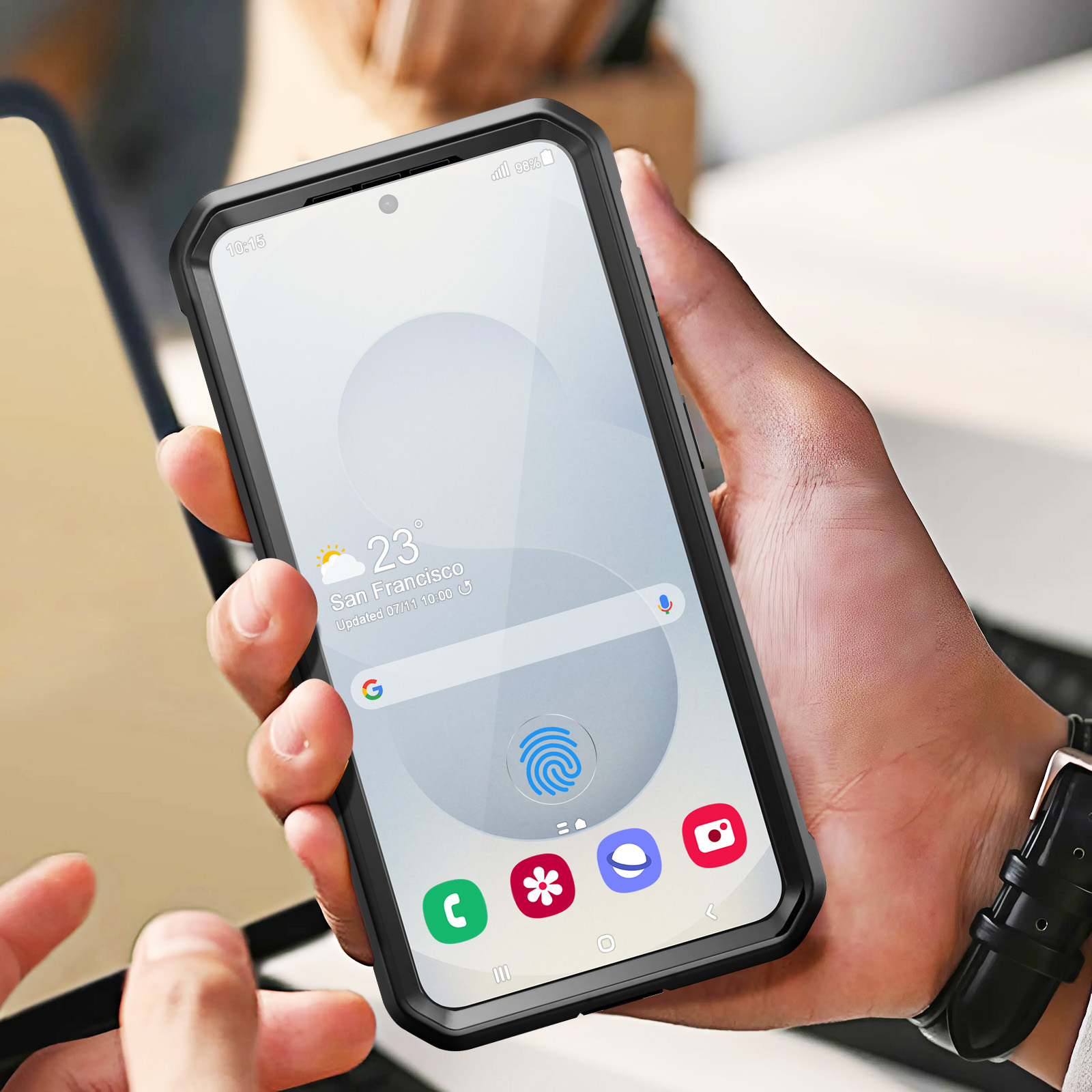 Eine Person hält ein Telefon in einer schwarzen Hülle. Das Telefon zeigt eine Karte von San Francisco und das Datum.