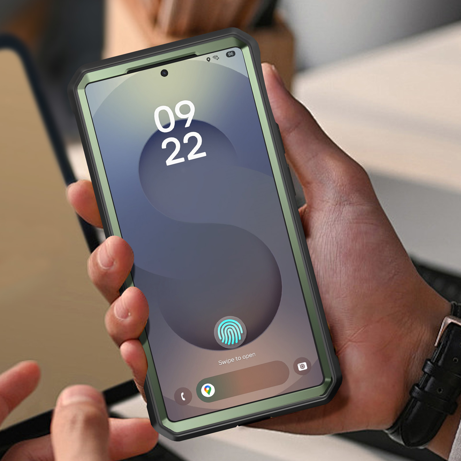 Eine Hand hält ein Telefon mit grünem Bildschirm und Schutzhülle.