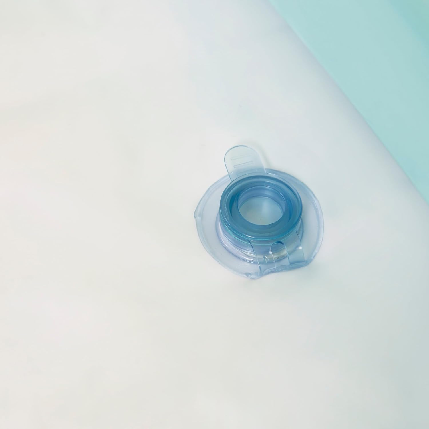 Zbliżenie jasnoniebieskiego i białego zaworu na białej i jasnoniebieskiej powierzchni.