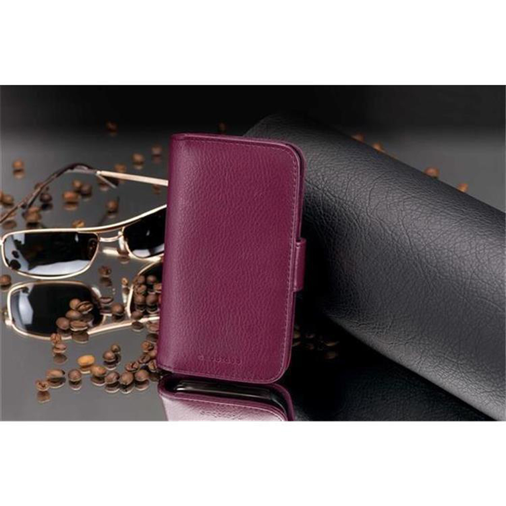 Un étui de téléphone en cuir violet avec des lunettes et des grains de café sur une surface sombre.