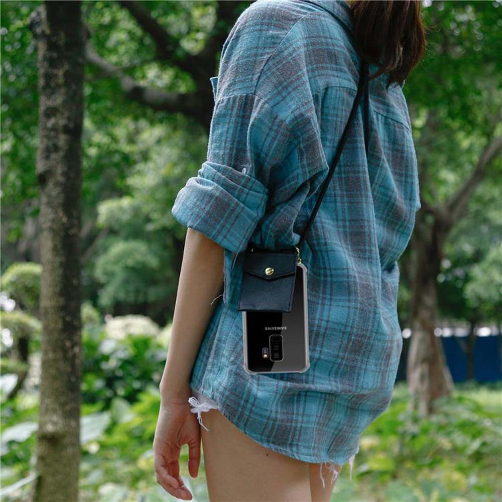 Una donna con una camicia a quadri blu indossa una custodia per telefono a tracolla, tenendo in mano il telefono.
