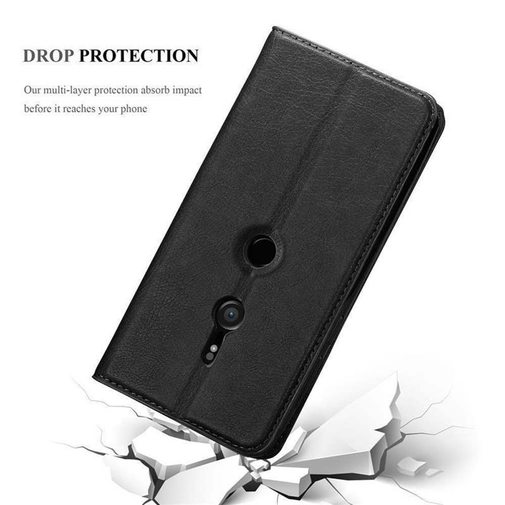 Eine schwarze Handyhülle mit einem Telefon darin. Die Hülle ist geöffnet, mit einem zerbrochenen Boden im Vordergrund.